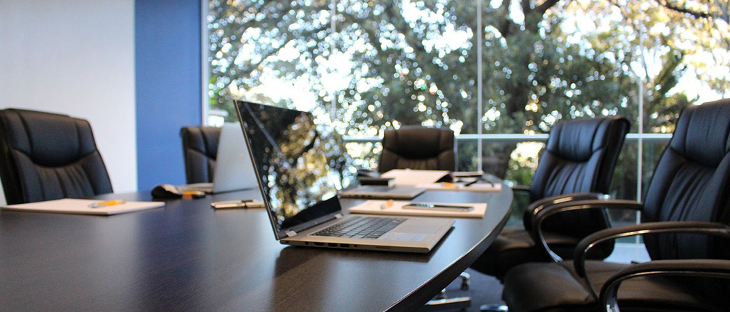 boardroom with laptop and papers